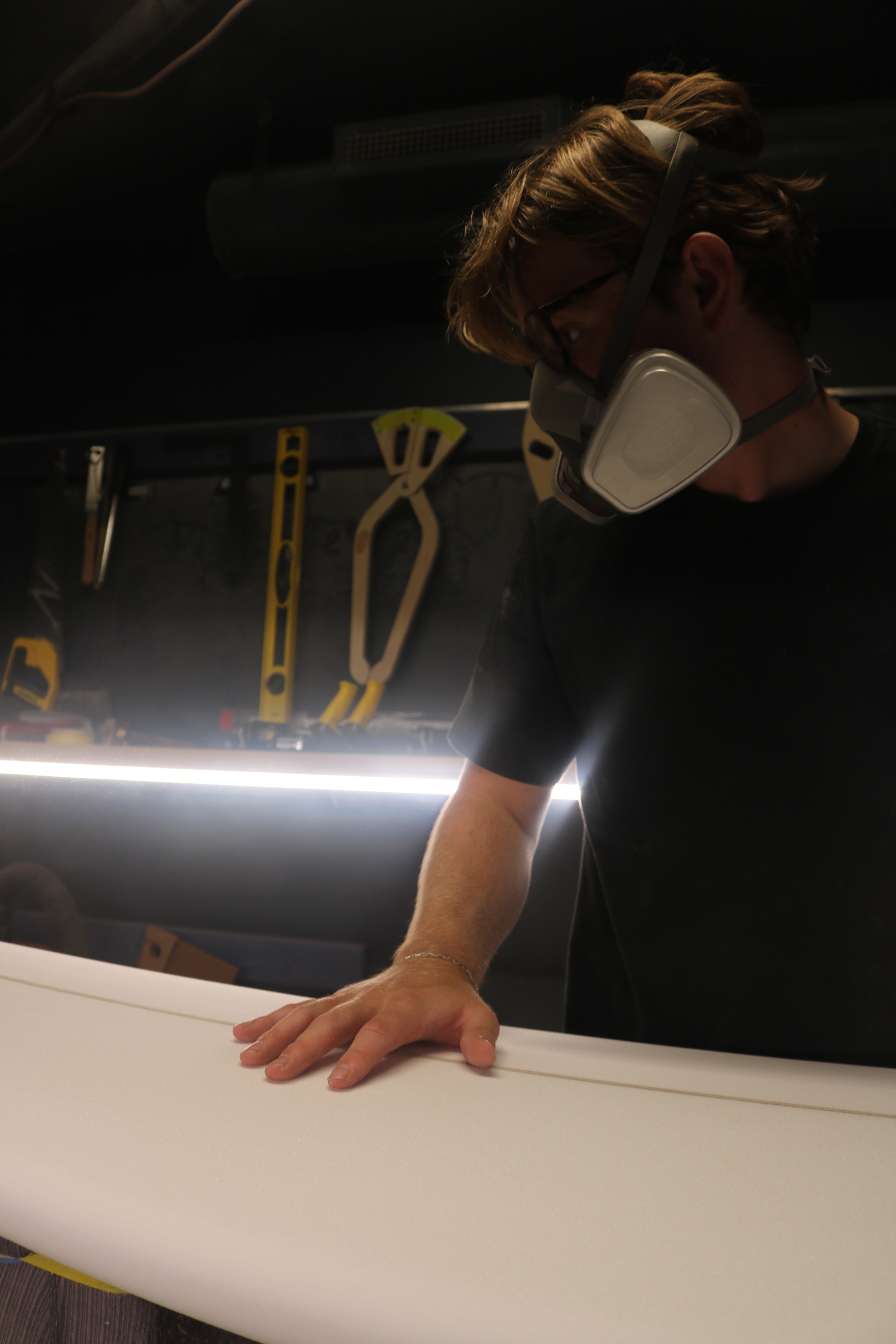 Shaper inspecting a board's rail